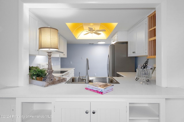 kitchen featuring stainless steel fridge, ceiling fan, range, white cabinets, and sink