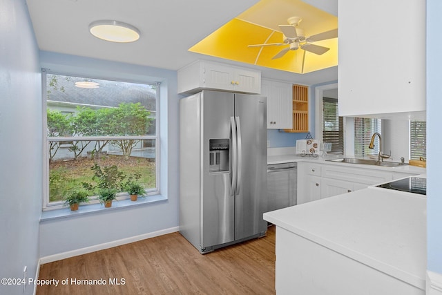 kitchen featuring ceiling fan, appliances with stainless steel finishes, light wood-type flooring, white cabinets, and sink