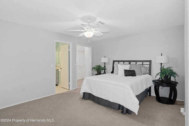 carpeted bedroom with ceiling fan, connected bathroom, a closet, and a walk in closet