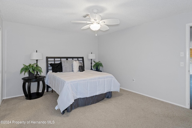 bedroom with ceiling fan, a textured ceiling, and light carpet