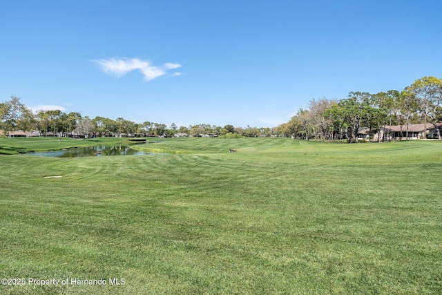 surrounding community with a water view and a yard