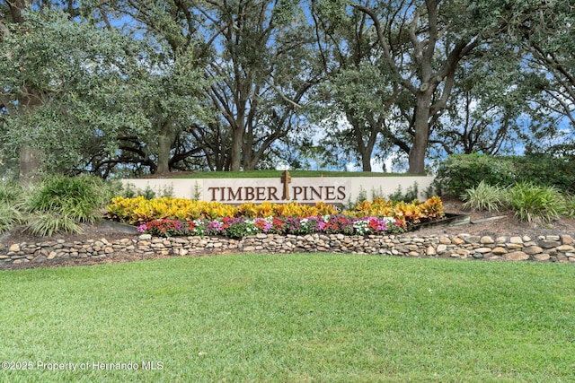 community / neighborhood sign featuring a yard