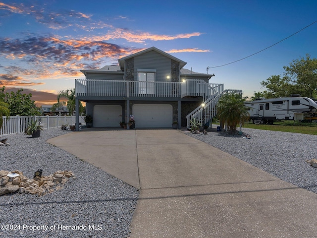 front of property with a garage and a wooden deck