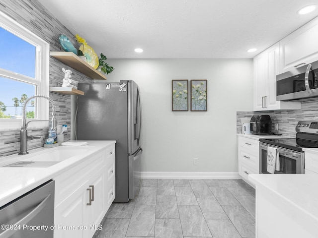 kitchen featuring decorative backsplash, sink, white cabinets, and stainless steel appliances