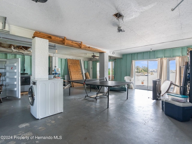 interior space featuring washer / clothes dryer, ceiling fan, and a textured ceiling