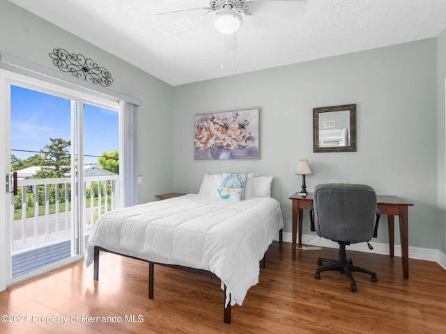 bedroom featuring access to outside, ceiling fan, wood-type flooring, and a textured ceiling