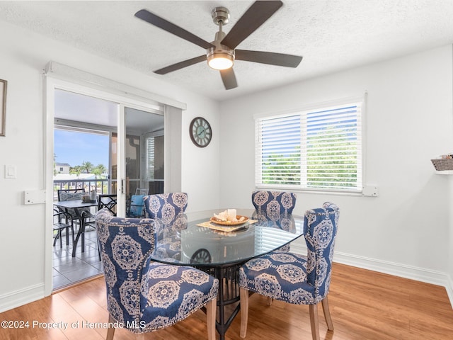 dining area featuring hardwood / wood-style floors, a textured ceiling, and ceiling fan