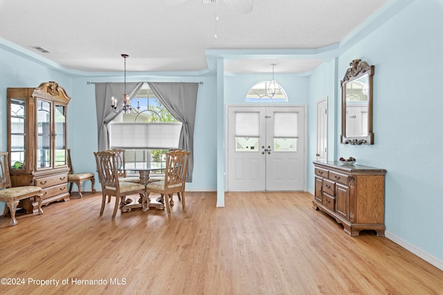 dining area with light wood-type flooring and ceiling fan with notable chandelier