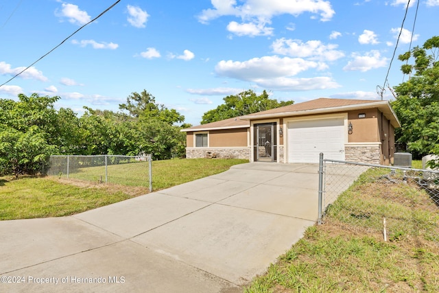 view of front of home featuring a front lawn, a garage, and central AC unit