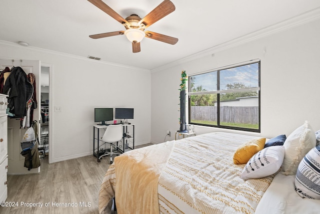 bedroom featuring a closet, crown molding, ceiling fan, and light hardwood / wood-style flooring