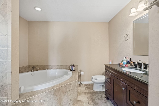 bathroom featuring tiled bath, vanity, and toilet