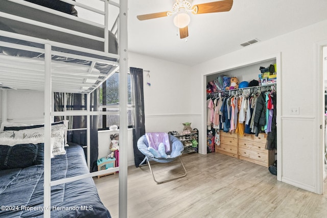 bedroom with hardwood / wood-style flooring, ceiling fan, and a closet