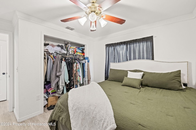 bedroom featuring ornamental molding, a closet, ceiling fan, and light hardwood / wood-style flooring