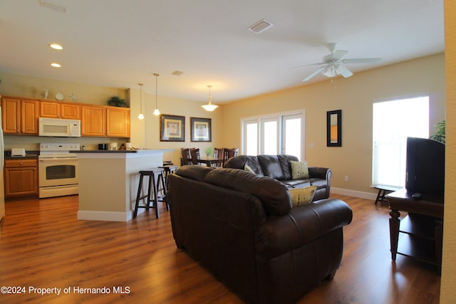 living room with ceiling fan and dark hardwood / wood-style flooring