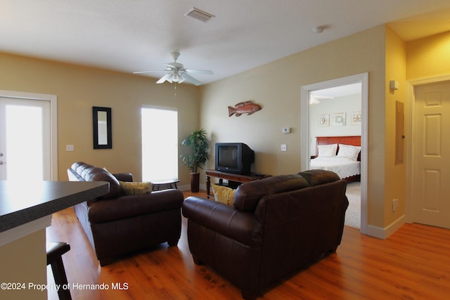 living room with dark hardwood / wood-style flooring and ceiling fan