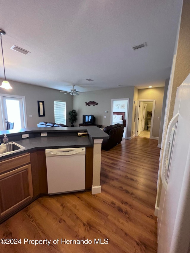 kitchen featuring dark hardwood / wood-style flooring, pendant lighting, white appliances, and ceiling fan