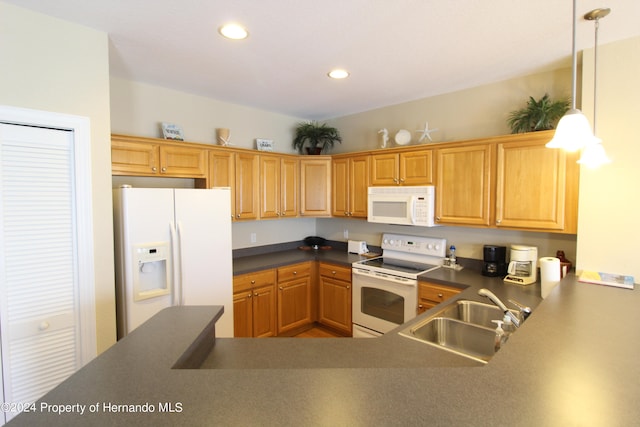 kitchen featuring pendant lighting, white appliances, and sink