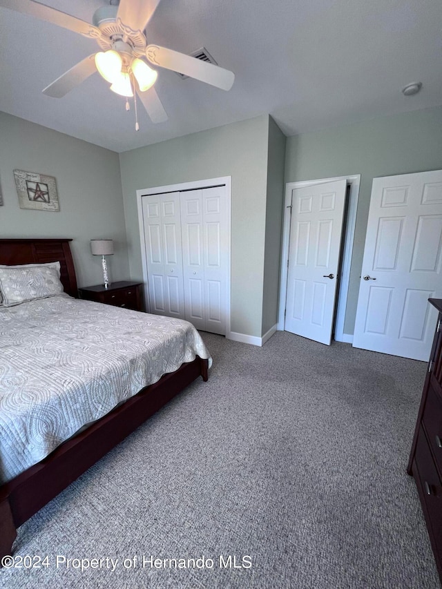 bedroom with ceiling fan, carpet flooring, and a closet