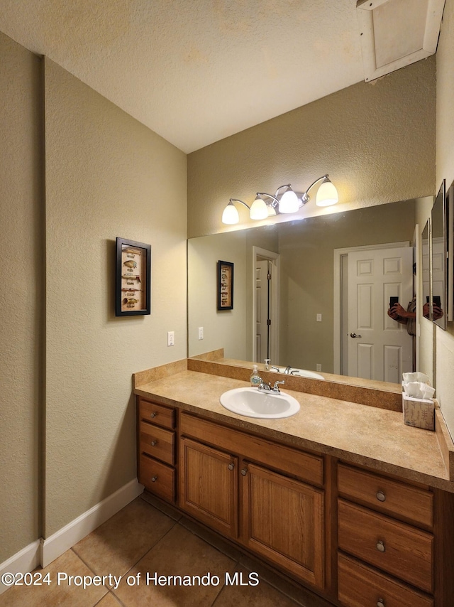 bathroom featuring tile patterned flooring, vanity, and a textured ceiling