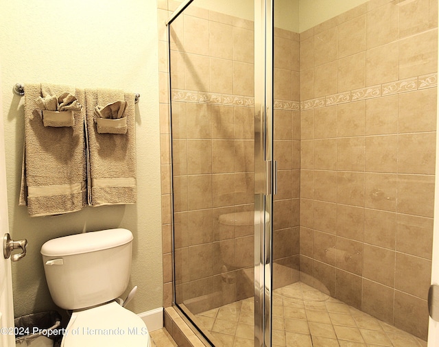 bathroom featuring toilet and a shower with shower door