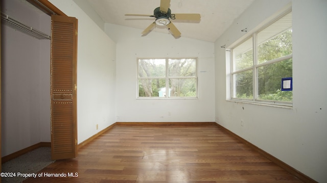 unfurnished bedroom featuring light hardwood / wood-style floors, lofted ceiling, multiple windows, and a closet