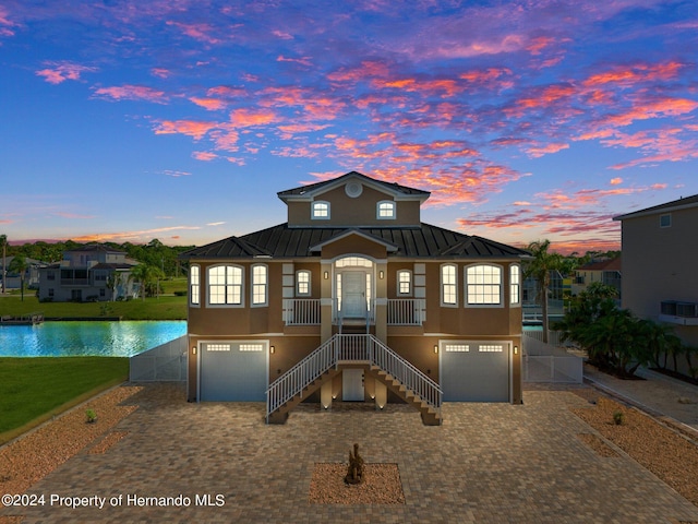 view of front of house featuring a garage and a water view