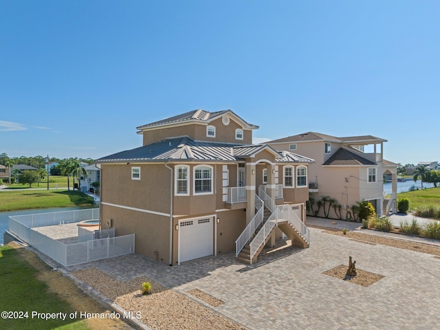 view of front of home with a garage and a water view