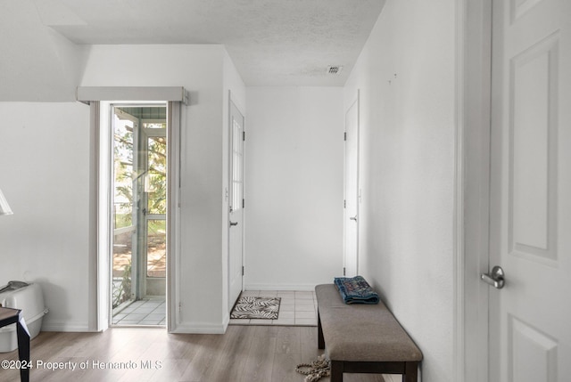 foyer featuring light hardwood / wood-style floors and a textured ceiling