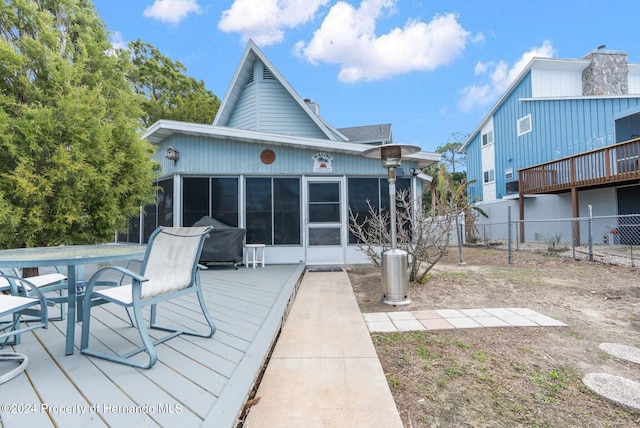 back of property with a sunroom and a wooden deck