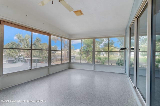 unfurnished sunroom with ceiling fan