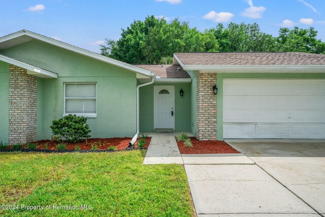 ranch-style house with a garage and a front lawn