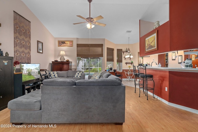 living room with ceiling fan, lofted ceiling, sink, and light hardwood / wood-style floors