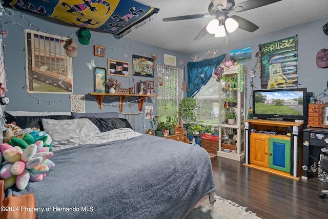 bedroom with dark wood-type flooring, ceiling fan, and a textured ceiling