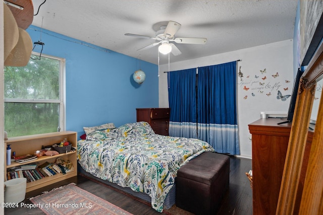 bedroom with dark hardwood / wood-style flooring, a textured ceiling, and ceiling fan