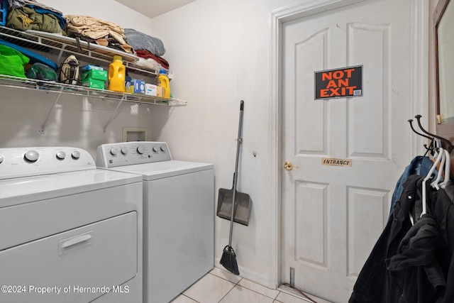 clothes washing area with washing machine and clothes dryer and light tile patterned floors