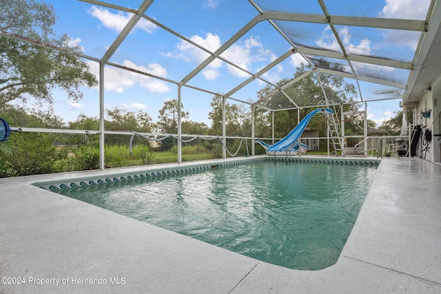 view of pool featuring a patio area, a lanai, and a water slide