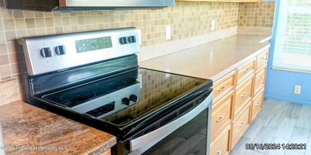 kitchen featuring decorative backsplash and electric range