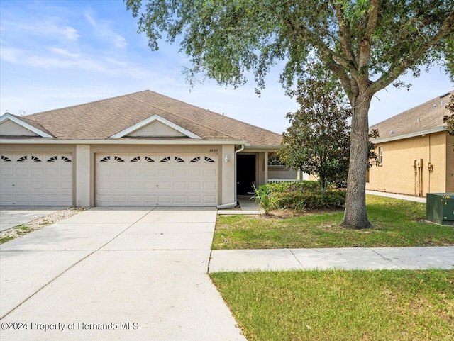 ranch-style house featuring a garage and a front yard