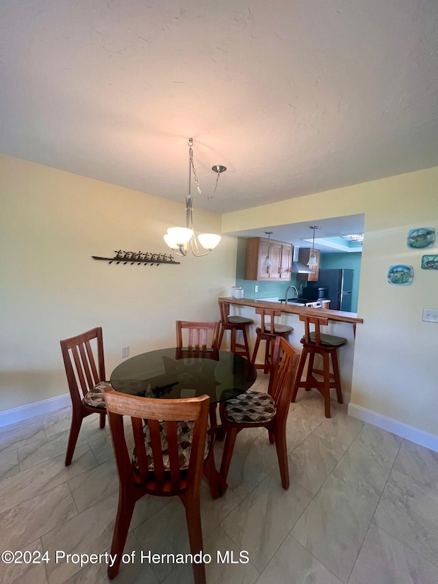 dining room with sink and an inviting chandelier