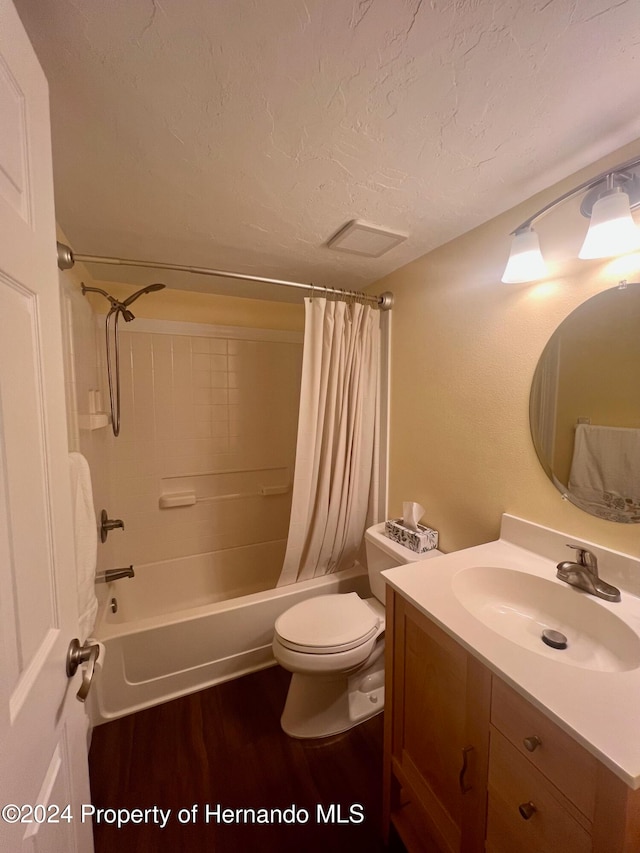 full bathroom with vanity, toilet, a textured ceiling, hardwood / wood-style flooring, and shower / tub combo with curtain