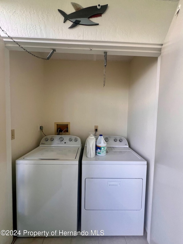 washroom with tile patterned flooring and washer and clothes dryer