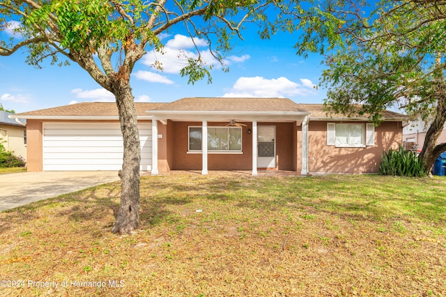 ranch-style house with a garage, a front lawn, and ceiling fan