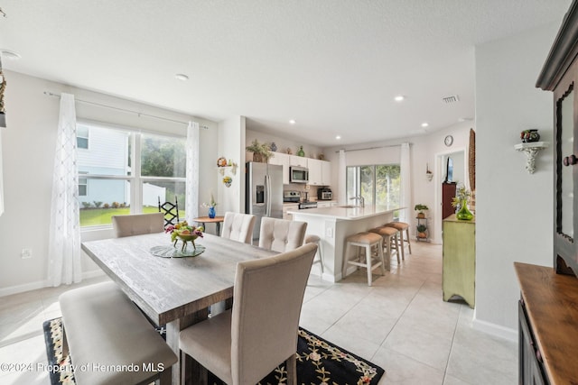 dining room with a textured ceiling and light tile patterned floors