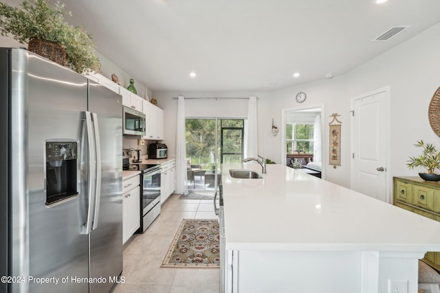 kitchen with white cabinets, sink, a center island with sink, and stainless steel appliances