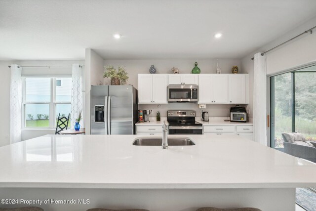 kitchen featuring appliances with stainless steel finishes, sink, a breakfast bar area, and plenty of natural light