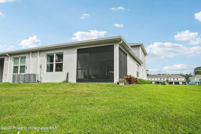 back of house featuring a sunroom and a lawn