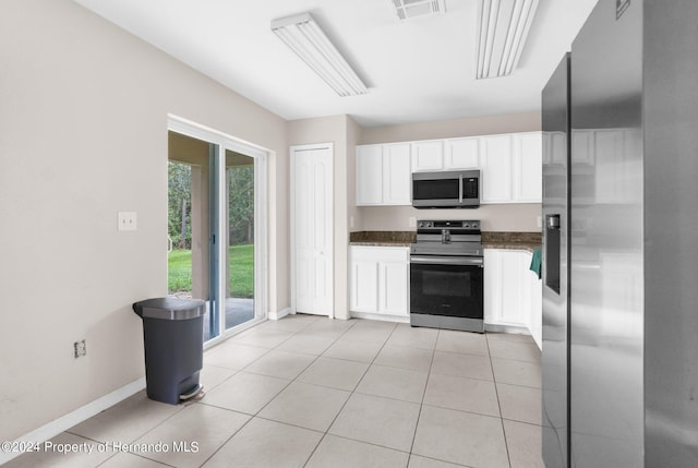 kitchen featuring white cabinets, appliances with stainless steel finishes, and light tile patterned floors