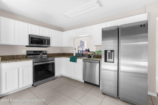 kitchen featuring light tile patterned floors, white cabinetry, sink, and appliances with stainless steel finishes