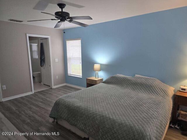 bedroom featuring ensuite bath, ceiling fan, and wood-type flooring