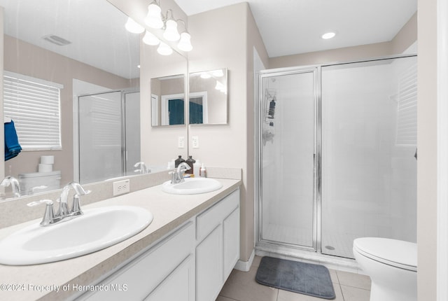 bathroom featuring tile patterned flooring, vanity, toilet, and walk in shower